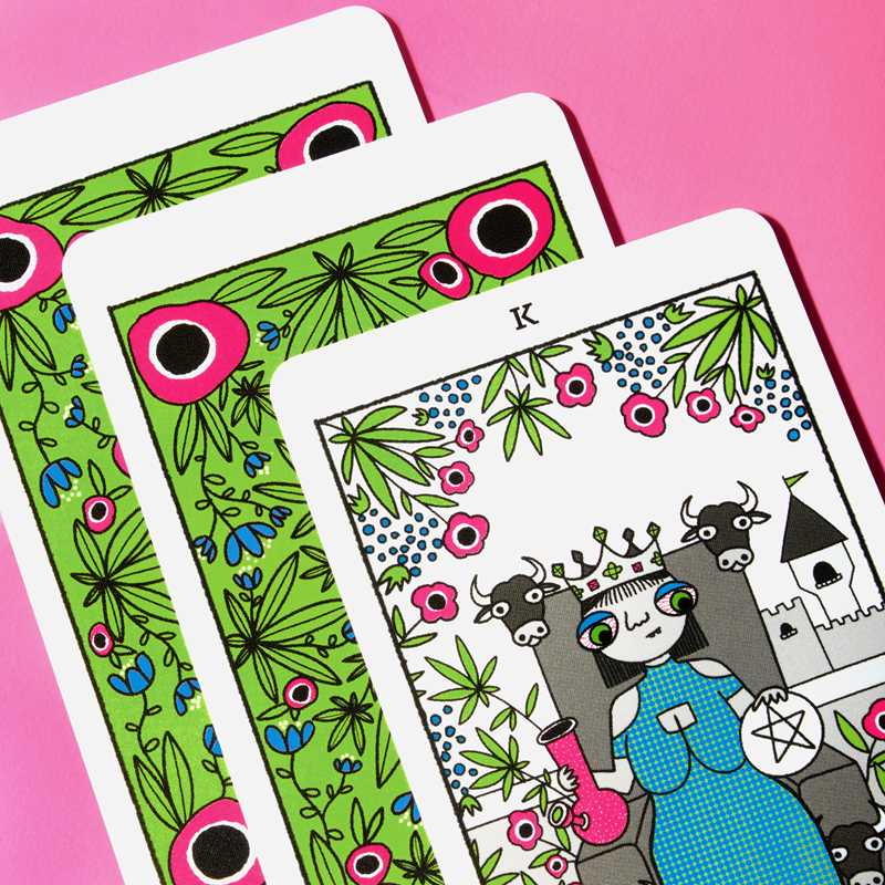 Colorful playing cards with decorative designs on a pink background