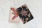 Two tarot cards on a textured surface, one with an eagle design and the other with floral patterns.