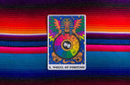 Colorful tarot card titled 'Wheel of Fortune' on a vibrant striped fabric background