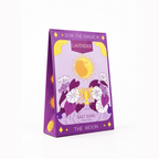 A purple triangular box of SOW THE MAGIC Lavender Salt Soak, featuring a whimsical illustration of a yellow sun, white flowers, and the text 'THE MOON' on a clean white background.