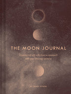 Book titled 'The Moon Journal' with moon phases on a dark background