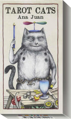 The front cover of the 'Tarot Cats' deck by Ana Juan, featuring a detailed illustration of a cat dressed as a tarot card with a propeller hat, holding a sword, standing behind a table with a cup and cards.
