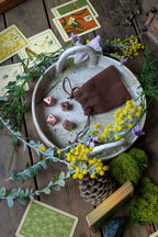 Decorative setting with tarot cards, crystals, and flowers on a wooden surface
