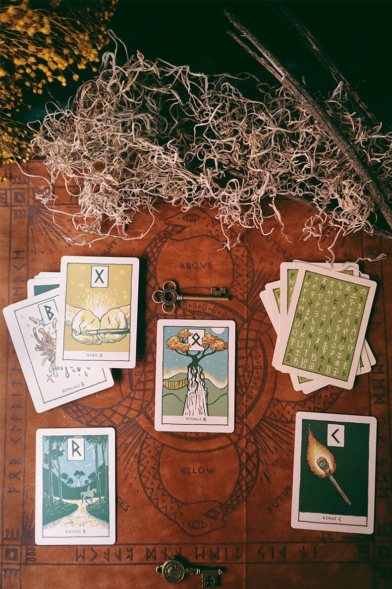 Tarot cards on a wooden surface with herbs and a key