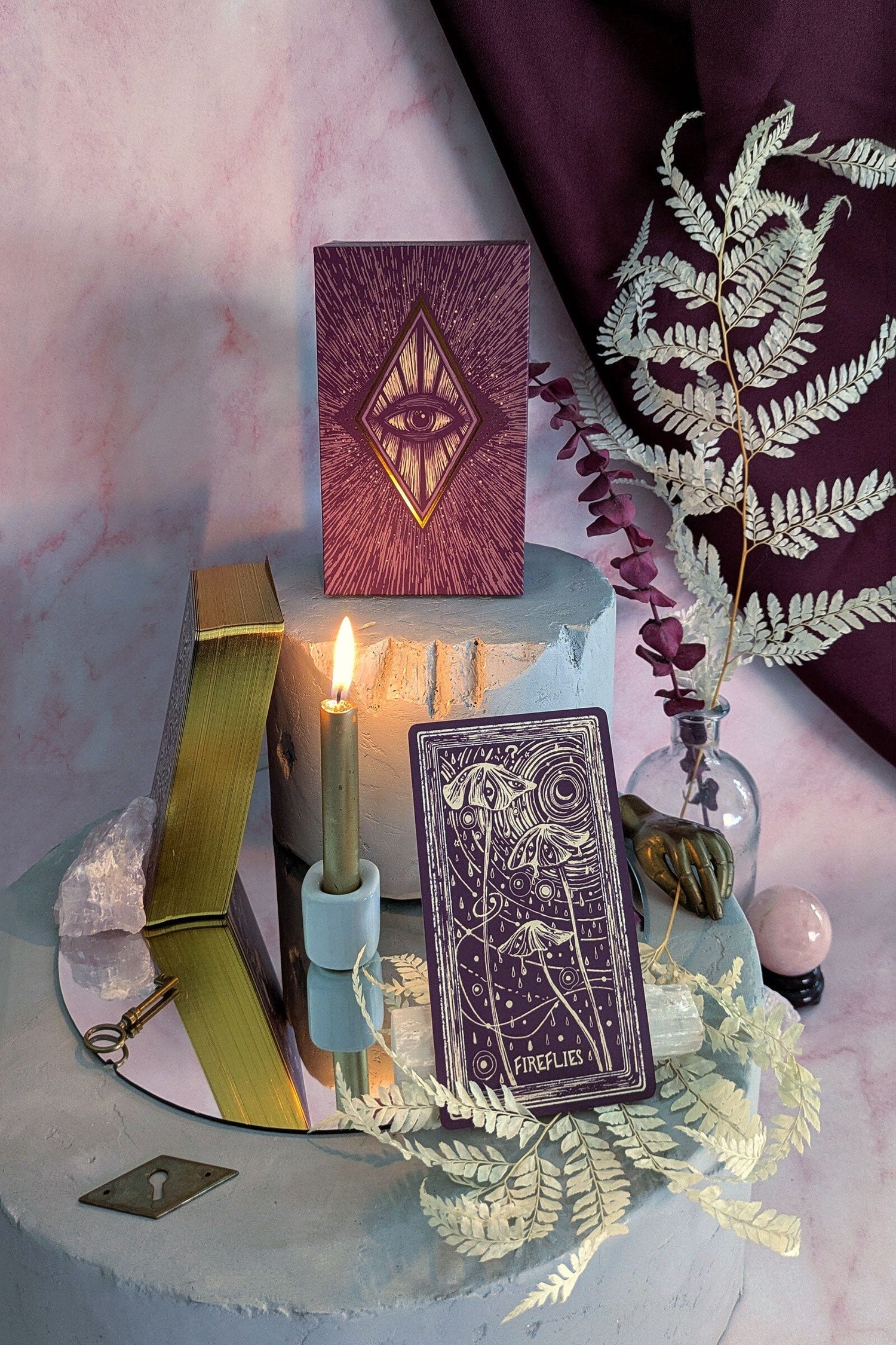 Decorative setup with tarot cards, candles, and decorative elements on a marble surface.