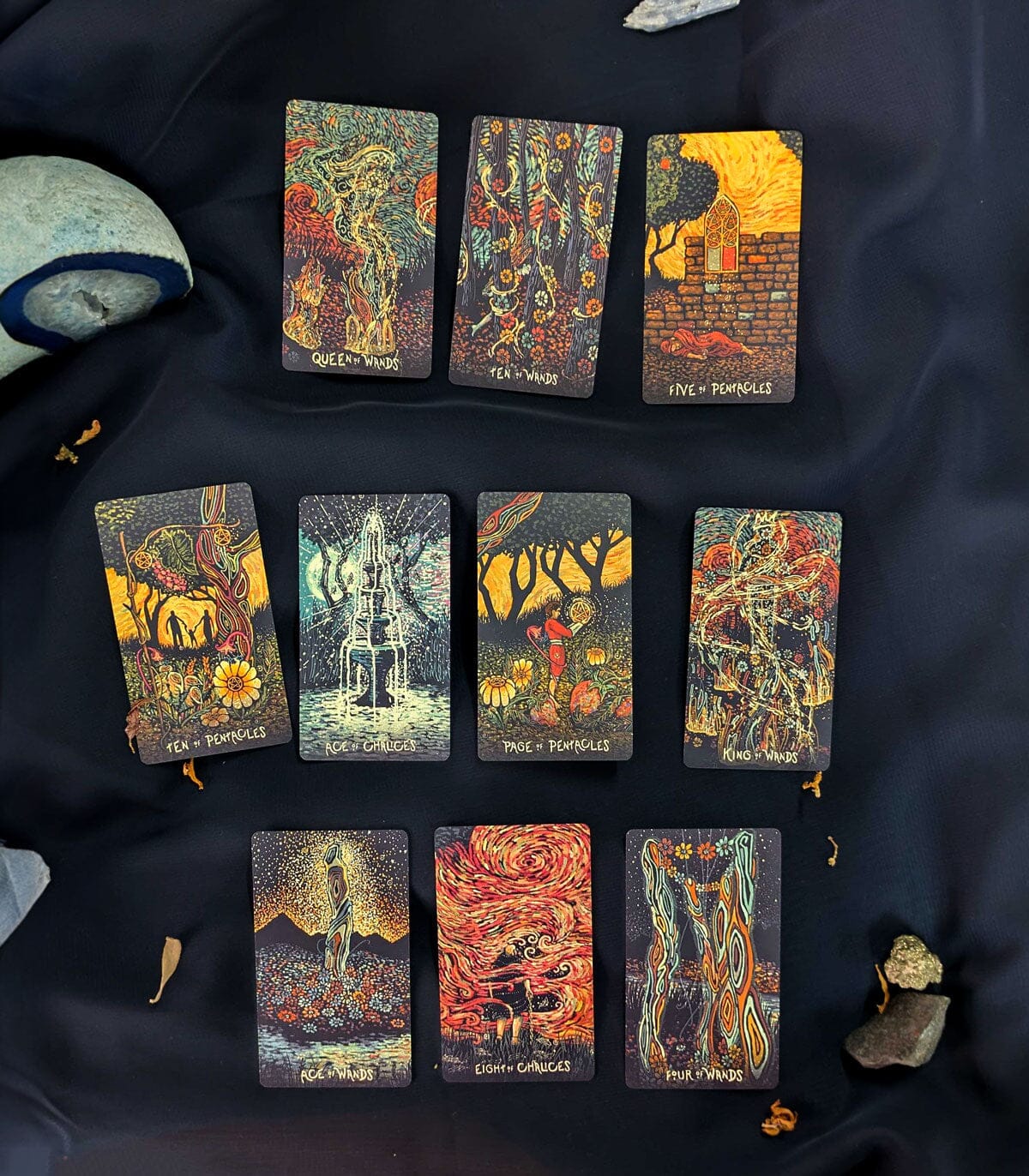 Collection of tarot cards with artistic designs on a dark fabric background
