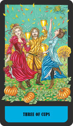 Three people holding cups in a festive setting with pumpkins and autumn leaves, labeled 'Three of Cups'.