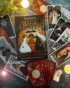 Tarot cards from 'Seasons of the Witch' Autumn Tarot set on a textured surface with candles and leaves.