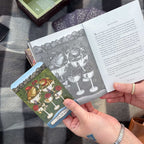 Person holding a book with illustrations and a matching card